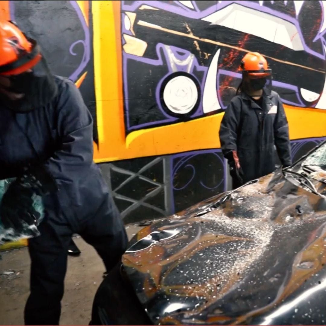 people smashing a car in a room