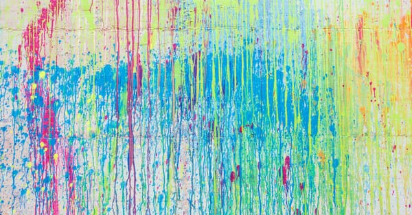 colorful paint splattered all over a white wall